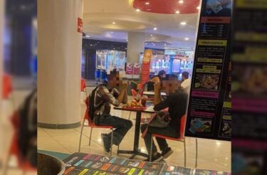 Jovens rezam no meio de um shopping pedindo ajuda com comida